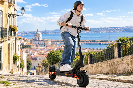 Young man with helmet riding JOYOR foldable off-road electric scooter on cobblestone hillside street, city river view background, urban commuting