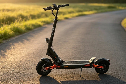 JOYOR high‑performance off‑road electric scooter with fat tires, stationary on winding rural road under warm golden hour sunlight